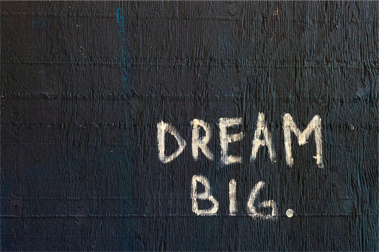 The words 'DREAM BIG' painted on the side of a wall